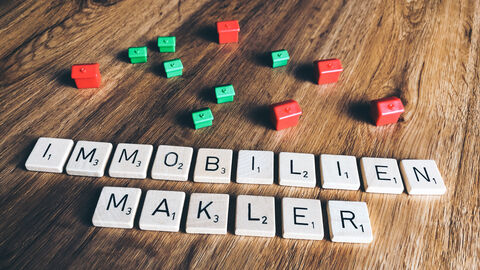 Scrabble-Steine bilden das Wort "Immobilienmakler".