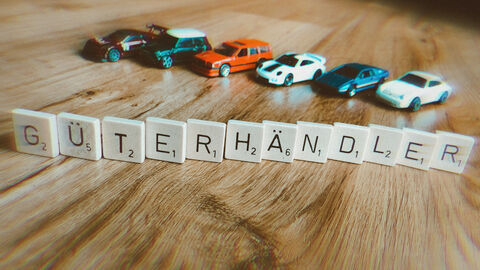 Scrabble-Steine bilden das Wort "Güterhändler". Scrabble-Steine bilden das Wort "Güterhändler".