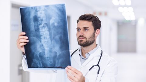 Ein Arzt schaut sich ein Röntgenbild an.