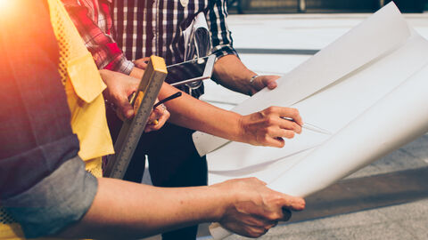 Ingenieure halten Pläne in der Hand