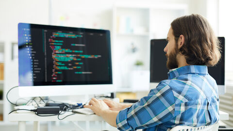 Ein IT-Mitarbeiter arbeitet an einer Computersoftware.