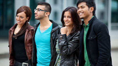 Junge Frauen und Männer gehen durch die Stadt. Junge Frauen und Männer gehen durch die Stadt.