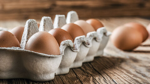 Ein gefüllter Eierkarton steht auf einem Tisch.