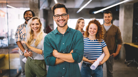 Junge motivierte Mitarbeiter schauen in die Kamera. Junge motivierte Mitarbeiter schauen in die Kamera.