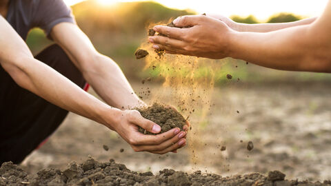 Bauern halten Erde auf einer Ackerfläche in den Händen. Bauern halten Erde auf einer Ackerfläche in den Händen.