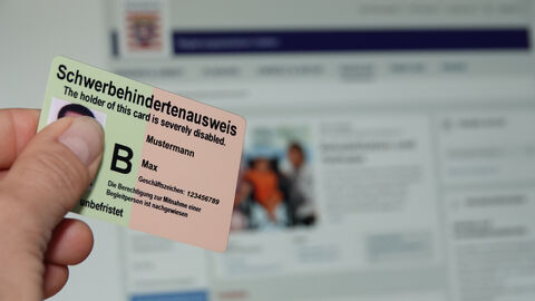 Ein Schwerbehindertenausweis wird vor einen PC gehalten