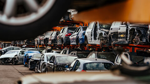 Beschädigte Autos, die auf einem Schrottplatz darauf warten, recycelt oder als Ersatzteile verwendet zu werden.