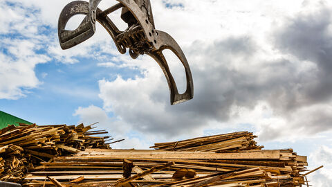 Ein Bündelgreifer lädt Holz.