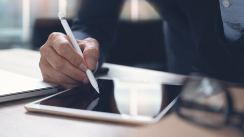 Ein Mann arbeitet am Tablet.