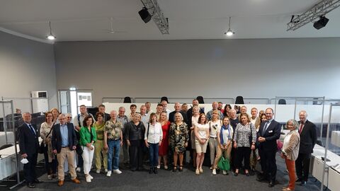 Rund 40 Frauen und Männer stehen im externen Sitzungssaal des Landgerichts