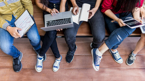 Junge Studenten und Auszubildende arbeiten an Notebook und Tablet.