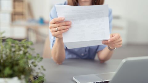 Frau Sitzt mit einem Brief am Laptop Frau Sitzt mit einem Brief am Laptop