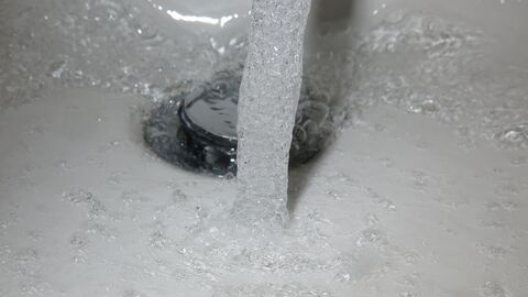 Wasser fließt in einen Abfluss Wasser fließt in einen Abfluss