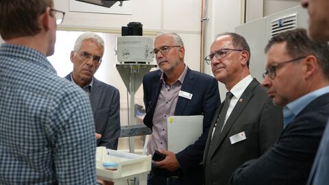 Dr. Christoph Ullrich (rechts) sowie die RP-Experten Michael Axmann (Mitte) und Stefan Wingenbach (links) lassen sich von den Mitarbeitern von OptoTech die zu kontrollierende Maschine erklären.