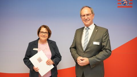 Dr. Christoph Ullrich gratuliert Ursula Rock zum Dienstjubiläum und überreicht eine Urkunde.