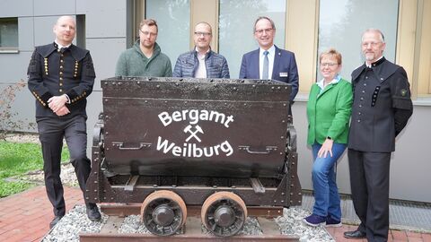 Freuen sich über die Rückkehr der Lore an den Standort an der Marburger Straße (von links): Hendrik Ebert (Dezernatsleiter Bergaufsicht), Tobias Dietz (Vorstand Förderverein Besucherbergwerk Fortuna e.V.), Reinhard Schönberger (Vorstand Förderverein Besucherbergwerk Fortuna e.V.), Dr. Christoph Ullrich (Regierungspräsident), Karin Ohm-Winter (Abteilungsleiterin Umwelt) und Ralf Ukleja (stellvertretender Dezernatsleiter Bergaufsicht).