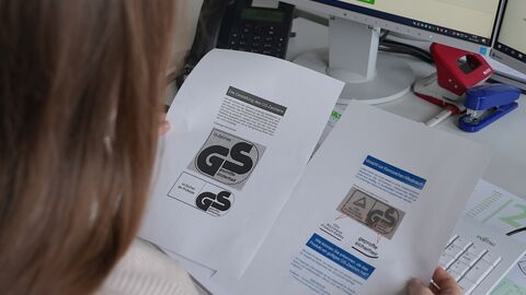 Eine Frau liest Informationen über das GS-Zeichen.