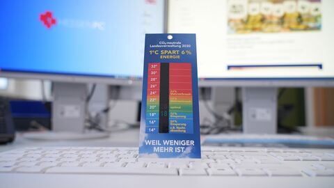 Ein Thermometer steht auf einer Tastatur und zeigt etwa 19 Grad Celsius an