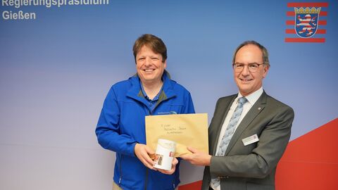 Regierungspräsident Dr. Christoph Ullrich übergibt die Spenden an Dr. Holger Hauch