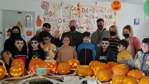 Abteilungsleiter Manfred Becker nimmt im Beisein der Kinder die geschnitzten Kürbisse beim Wettbewerb in Augenschein.