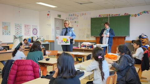Mit Zeichnungen präsentieren Polizistin Claudia Meyer (vorne) und Polizei-Jugendkoordinatorin Antje Suppmann (hinten) den Flüchtlingskindern der Lernstoff auf eine für sie verständliche Weise. 