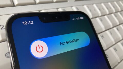 Ein Handy liegt auf einer Tastatur. Es ist bereit zum Ausschalten.