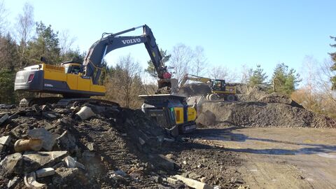 Bagger läd Schutt auf einen einen LKW