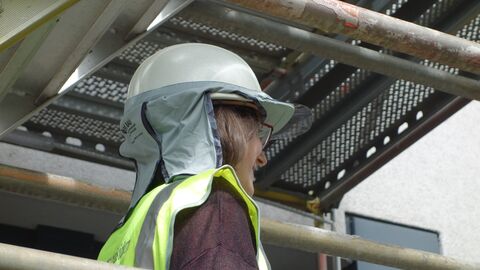 Eine Frau mit Helm samt Sonnenschutz für den Nacken