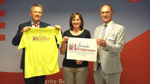 Dr. Christoph Ullrich, Martin Rößler und Sabrina Panz zeigen das Logo zum Slogan "1 Arbeitgeber, 1000 Möglichkeiten"