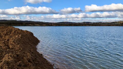 Blick auf einen Baggersee, der gerade verfüllt wird