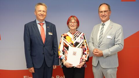 Dr. Christoph Ullrich und Martin Rößler überreichen Ruth Böhr ihre Urkunde zum Abschied