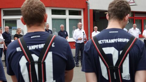 Bezirksentscheid Christoph Ullrich steht vor Feuerwehrleuten und hält eine Rede