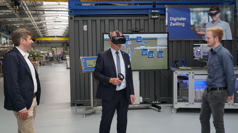 Tobias Weber (l.) und Manuel Wunderlich (r.) wiesen Dr. Christoph Ullrich in die Nutzung des „digitalen Zwillings“ ein, mit dessen Hilfe Produktionslinien vor der Konstruktion virtuell in den Werkshallen erprobt werden können.