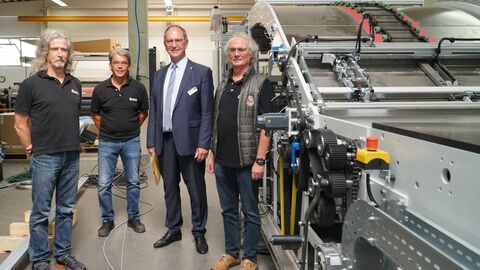 Lothar Stock (l.), Karlheinz Hellweg (2.v.l.) und Günter Stock (r.) zeigen Regierungspräsident Dr. Christoph Ullrich in der eigenen Werkshalle die Montage einer Kaschiermaschine.