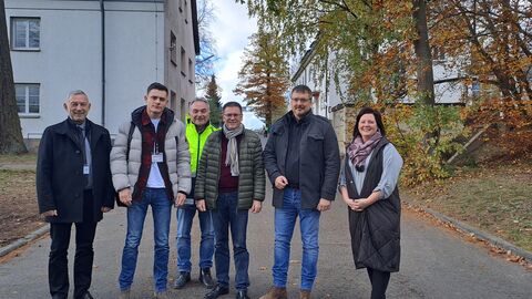 Besuch in Erstaufnahmeeinrichtung Die Besucher der Erstaufnahmeeinrichtung stehen vor den Gebäuden.