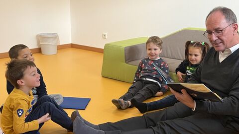 Vorlesetag mit Regierungspräsident Dr. Ullrich Regierungspräsident Dr. Ullrich liest Kindern aus einem Buch vor.