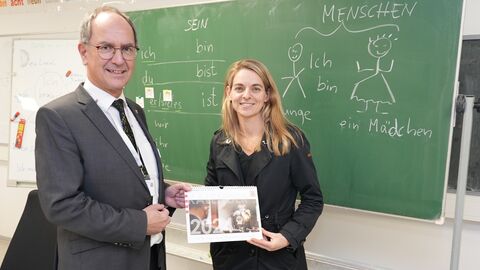 Dr. Christoph Ullrich verabschiedet Nia Künzer und überreicht ihr einen Kalender für 2024.