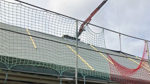 Foto von einem Dach und einem Gerüst, das mit Netzen gesichert ist