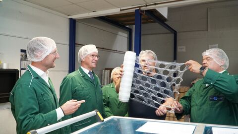 Roman Kardapolow (2.v.r.) und Johannes van Horrick (r.) erläutern Landrat Dr. Jens Mischak (l.) und Regierungspräsident Dr. Christoph Ullrich (2.v.l.) die Herstellung und die Einsatzmöglichkeiten von Stretchfolien für den Versand von Gütern und Waren. Im Hintergrund ist noch Mitarbeiterin Xenia Schmidt zu sehen.