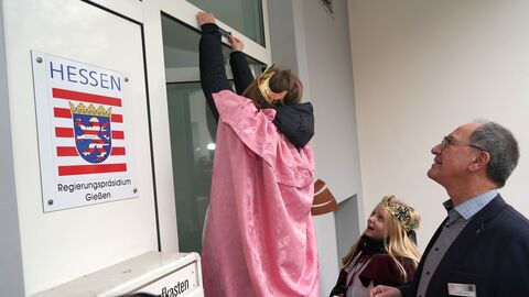 Ein Sternsinger bringt den Segen an der Tür des Regierungspräsidiums in Gießen an