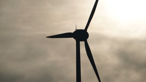 Ein Windrad vor einem bewölkten Himmel