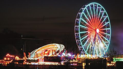 Blick auf die Gießener Messe mit ihren Fahrgeschäften bei Nacht