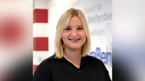 Britta Jüngst Ein Portraitfoto von Britta Jüngst. Frau Jüngst trägt schulterlanges blondes Haar und eine schwarze Bluse. Sie lächelt in die Kamera.
