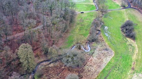 Blick auf einen Fluss aus der Vogelperspektive, zu sehen sind auch Bäume und Felder