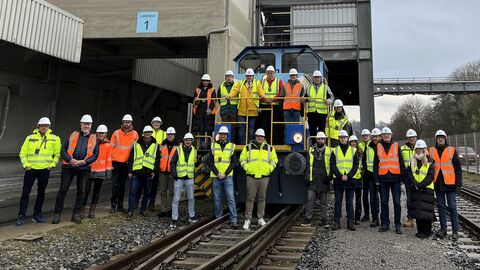 Die Teilnehmerinnen und Teilnehmer des Treffens haben sich vor und auf einer großen Lok zum Gruppenfoto aufgestellt.